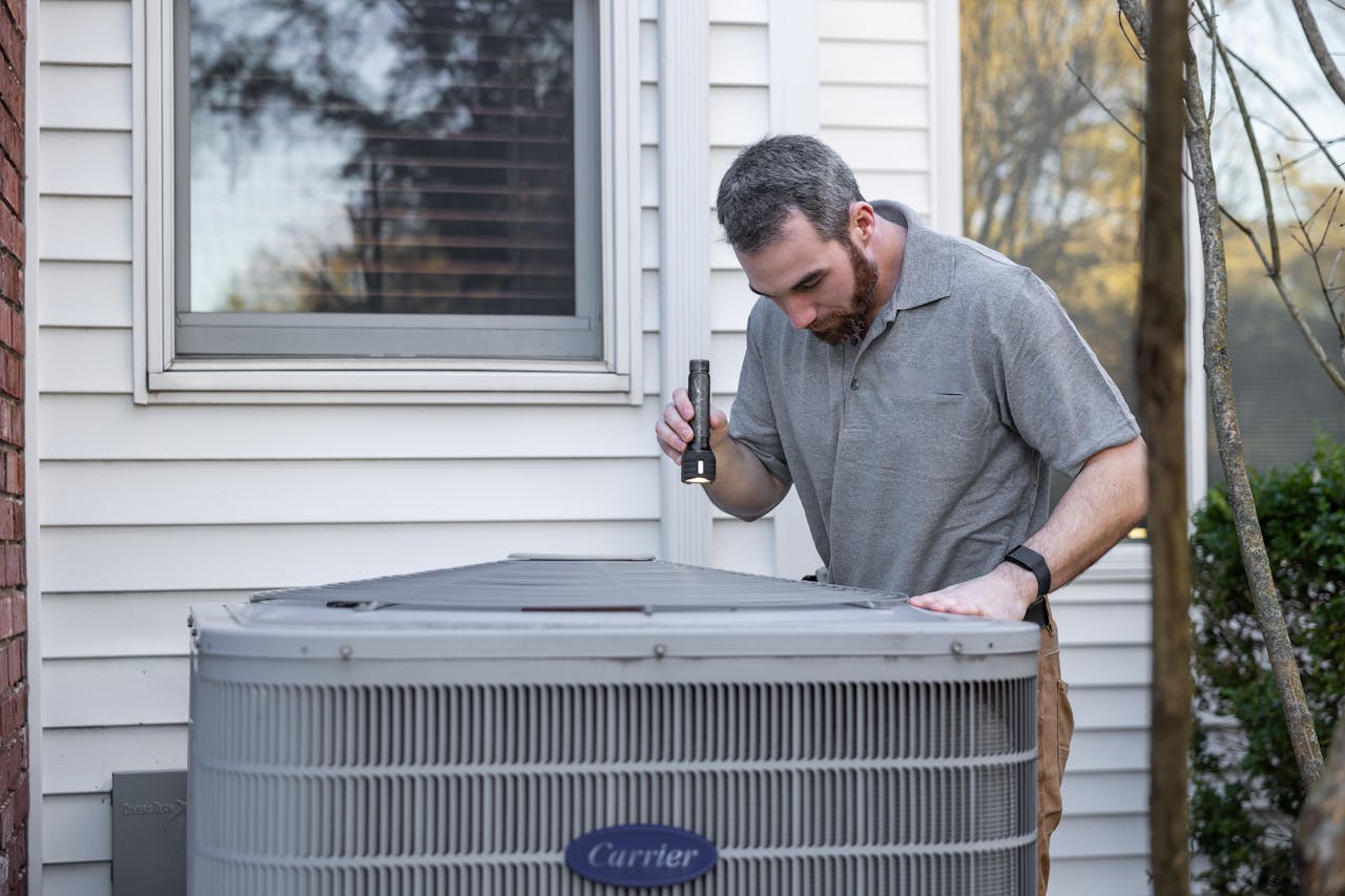our-journey-02 A technician inspects an outdoor HVAC unit for maintenance.